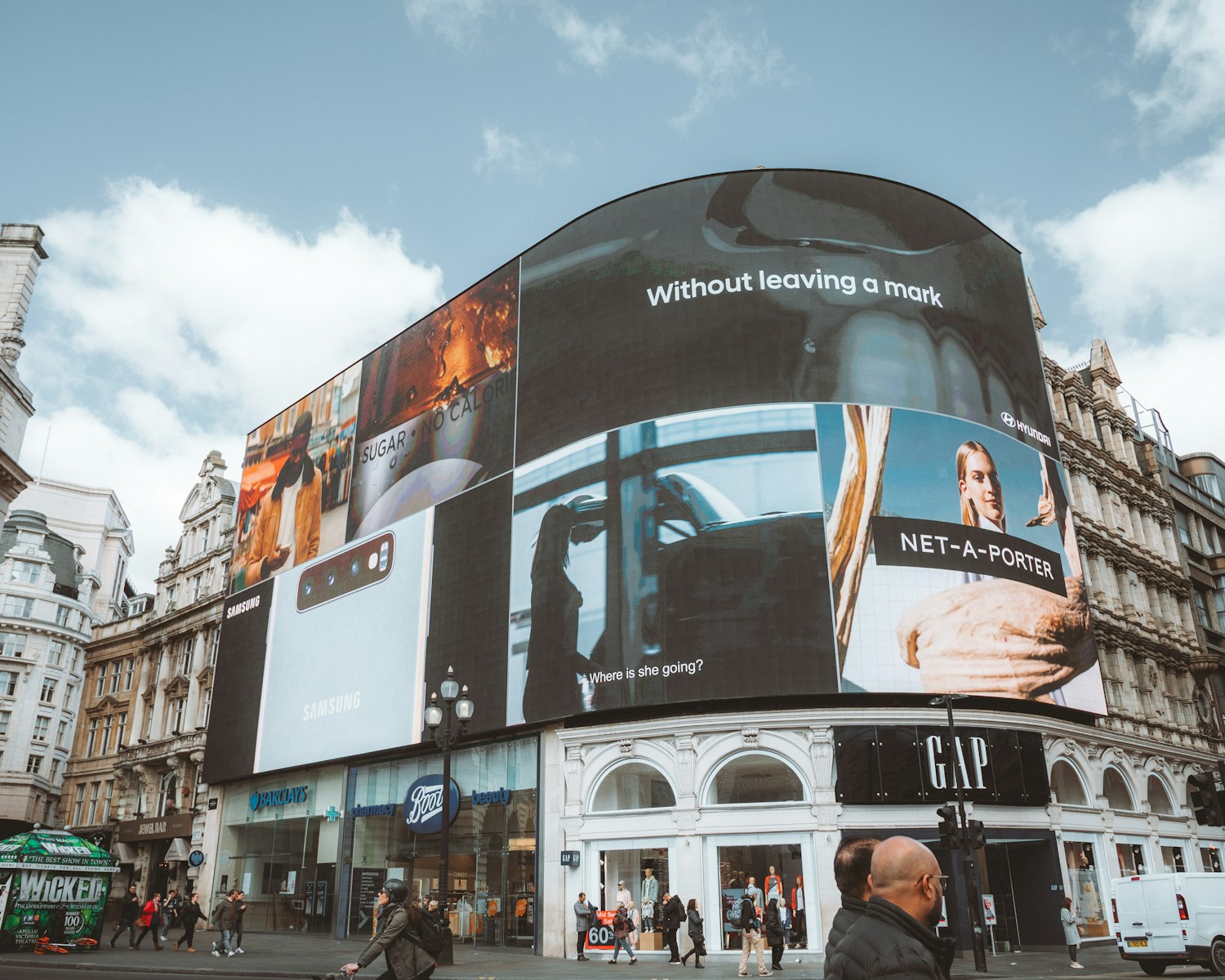 Large curved building with many digital billboards
